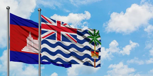 Bandera de Camboya y del Territorio Británico del Océano Índico ondeando en el viento contra el cielo azul nublado blanco juntos. Concepto diplomático, relaciones internacionales . — Foto de Stock