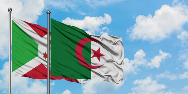 Burundi e Argélia acenando com o vento contra o céu azul nublado branco juntos. Conceito de diplomacia, relações internacionais . — Fotografia de Stock
