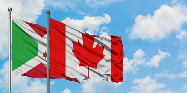 Bandera de Burundi y Canadá ondeando en el viento contra el cielo azul nublado blanco juntos. Concepto diplomático, relaciones internacionales . — Foto de Stock