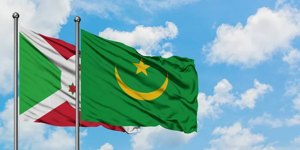 Bandera de Burundi y Mauritania ondeando en el viento contra el cielo azul nublado blanco juntos. Concepto diplomático, relaciones internacionales . — Foto de Stock