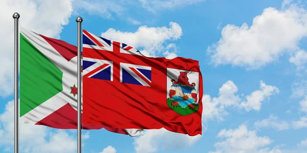 Bandera de Burundi y Bermudas ondeando en el viento contra el cielo azul nublado blanco juntos. Concepto diplomático, relaciones internacionales . — Foto de Stock