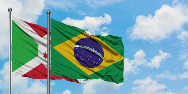 Флаг Бурунди и Бразилии размахивает ветром против белого облачно-синего неба вместе. Концепция дипломатии, международные отношения . — стоковое фото