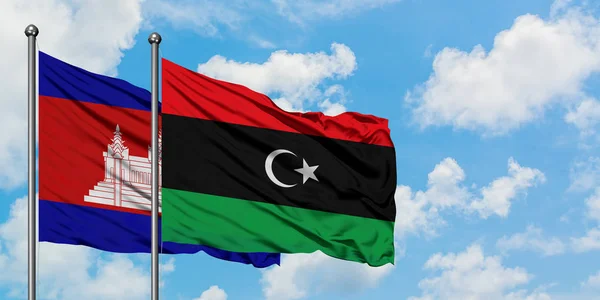 Stock image Cambodia and Libya flag waving in the wind against white cloudy blue sky together. Diplomacy concept, international relations.