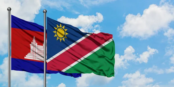 Cambodja en Namibië vlag zwaaien in de wind tegen witte bewolkte blauwe hemel samen. Diplomatie concept, internationale betrekkingen. — Stockfoto