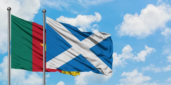 Cameroon and Scotland flag waving in the wind against white cloudy blue sky together. Diplomacy concept, international relations.