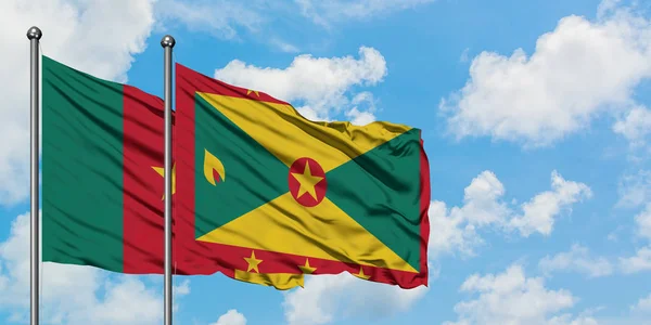 Drapeau du Cameroun et de la Grenade agitant dans le vent contre ciel bleu nuageux blanc ensemble. Concept de diplomatie, relations internationales . — Photo