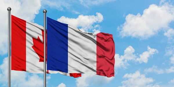 Bandera de Canadá y Francia ondeando en el viento contra el cielo azul nublado blanco juntos. Concepto diplomático, relaciones internacionales . — Foto de Stock