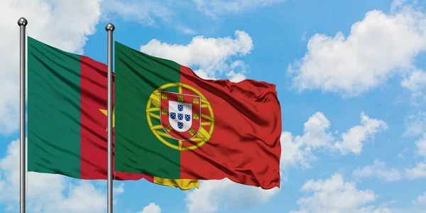 Bandera de Camerún y Portugal ondeando en el viento contra el cielo azul nublado blanco juntos. Concepto diplomático, relaciones internacionales . — Foto de Stock