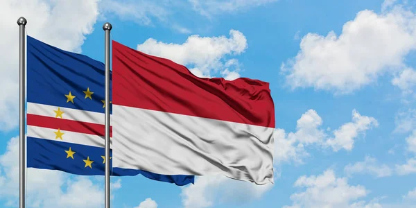 Bandera de Cabo Verde e Indonesia ondeando en el viento contra el cielo azul nublado blanco juntos. Concepto diplomático, relaciones internacionales . — Foto de Stock