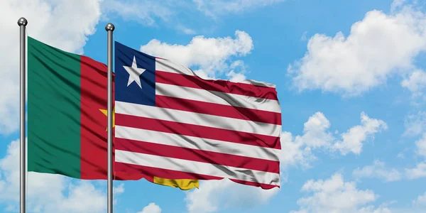 一緒に白い曇り青い空に対して風に手を振るカメルーンとリベリアの旗。外交概念、国際関係. — ストック写真