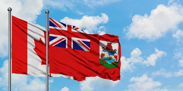 Bandera de Canadá y Bermudas ondeando en el viento contra el cielo azul nublado blanco juntos. Concepto diplomático, relaciones internacionales . — Foto de Stock