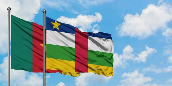 Bandera de Camerún y República Centroafricana ondeando en el viento contra el cielo azul nublado blanco juntos. Concepto diplomático, relaciones internacionales . — Foto de Stock