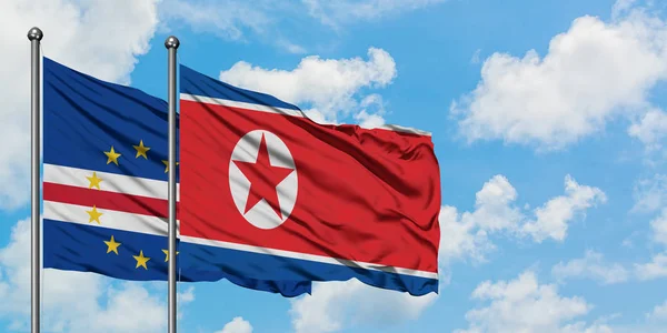 佛得角和朝鲜国旗在风中飘扬，共同面对白云蓝天。外交概念、国际关系. — 图库照片