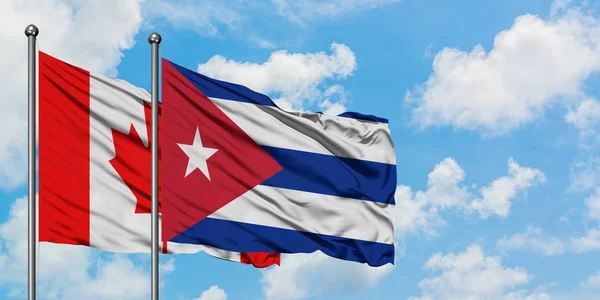 Bandera de Canadá y Cuba ondeando en el viento contra el cielo azul nublado blanco juntos. Concepto diplomático, relaciones internacionales . — Foto de Stock