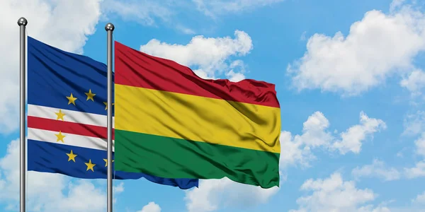 Bandera de Cabo Verde y Bolivia ondeando en el viento contra el cielo azul nublado blanco juntos. Concepto diplomático, relaciones internacionales . — Foto de Stock