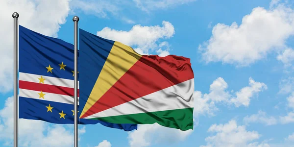 Bandera de Cabo Verde y Seychelles ondeando en el viento contra el cielo azul nublado blanco juntos. Concepto diplomático, relaciones internacionales . — Foto de Stock