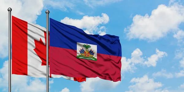 Kanada ve Haiti bayrağı birlikte beyaz bulutlu mavi gökyüzüne karşı rüzgarda sallayarak. Diplomasi kavramı, uluslararası ilişkiler. — Stok fotoğraf