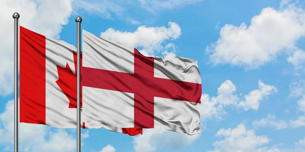 Canada en Engeland vlag zwaaien in de wind tegen witte bewolkte blauwe hemel samen. Diplomatie concept, internationale betrekkingen. — Stockfoto