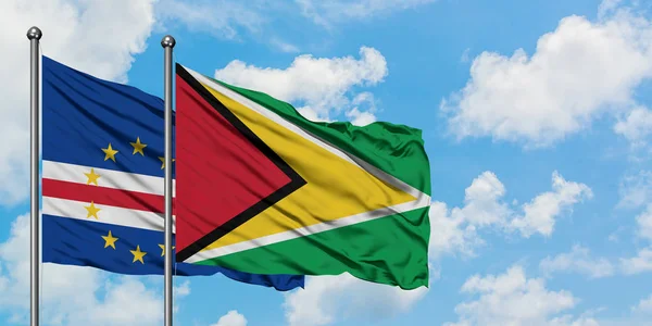 Bandera de Cabo Verde y Guyana ondeando en el viento contra el cielo azul nublado blanco juntos. Concepto diplomático, relaciones internacionales . — Foto de Stock