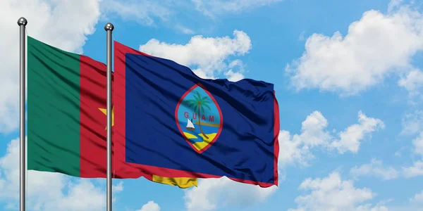 Cameroon and Guam flag waving in the wind against white cloudy blue sky together. Diplomacy concept, international relations. — Stock Photo, Image