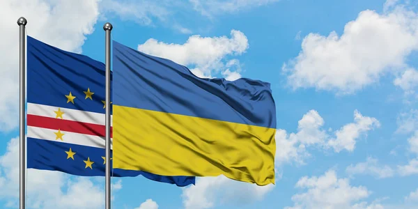 Bandera de Cabo Verde y Ucrania ondeando en el viento contra el cielo azul nublado blanco juntos. Concepto diplomático, relaciones internacionales . — Foto de Stock