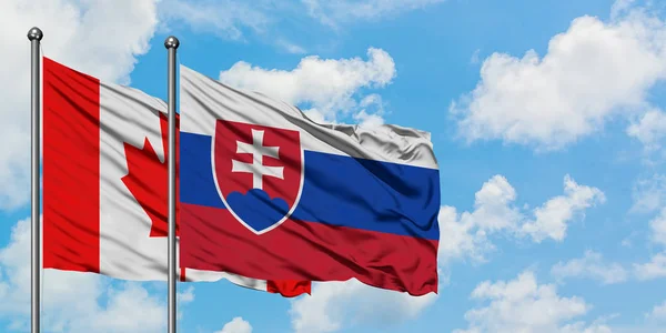 Kanada och Slovakien flagga vifta i vinden mot vit grumlig blå himmel tillsammans. Diplomatisk koncept, internationella relationer. — Stockfoto