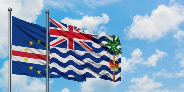 Bandera de Cabo Verde y del Territorio Británico del Océano Índico ondeando en el viento contra el cielo azul nublado blanco juntos. Concepto diplomático, relaciones internacionales . — Foto de Stock