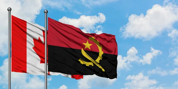 Bandera de Canadá y Angola ondeando en el viento contra el cielo azul nublado blanco juntos. Concepto diplomático, relaciones internacionales . —  Fotos de Stock