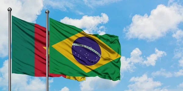 Bandera de Camerún y Brasil ondeando en el viento contra el cielo azul nublado blanco juntos. Concepto diplomático, relaciones internacionales . — Foto de Stock