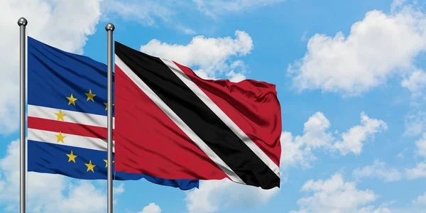 Bandera de Cabo Verde y Trinidad y Tobago ondeando en el viento contra el cielo azul nublado blanco juntos. Concepto diplomático, relaciones internacionales . — Foto de Stock