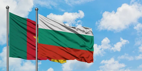 Bandera de Camerún y Bulgaria ondeando en el viento contra el cielo azul nublado blanco juntos. Concepto diplomático, relaciones internacionales . — Foto de Stock