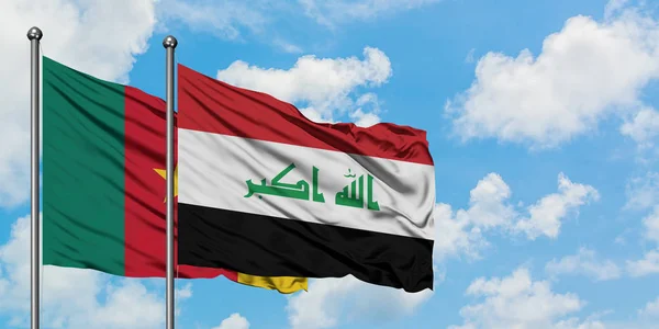 Bandera de Camerún e Irak ondeando en el viento contra el cielo azul nublado blanco juntos. Concepto diplomático, relaciones internacionales . — Foto de Stock
