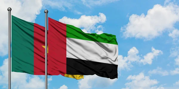 Bandera de Camerún y Emiratos Árabes Unidos ondeando en el viento contra el cielo azul nublado blanco juntos. Concepto diplomático, relaciones internacionales . — Foto de Stock