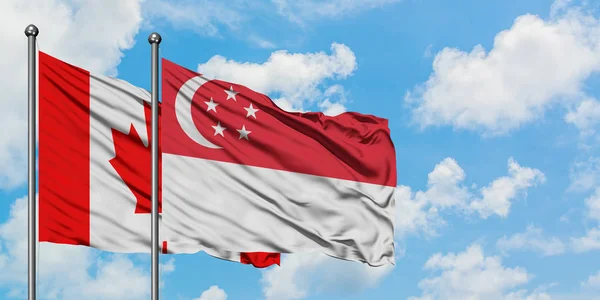 Kanada und Singapore-Flagge wehen gemeinsam im Wind gegen den wolkenverhangenen blauen Himmel. Diplomatie-Konzept, internationale Beziehungen. — Stockfoto