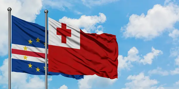 Bandera de Cabo Verde y Tonga ondeando en el viento contra el cielo azul nublado blanco juntos. Concepto diplomático, relaciones internacionales . — Foto de Stock