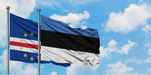 Bandera de Cabo Verde y Estonia ondeando en el viento contra el cielo azul nublado blanco juntos. Concepto diplomático, relaciones internacionales . — Foto de Stock