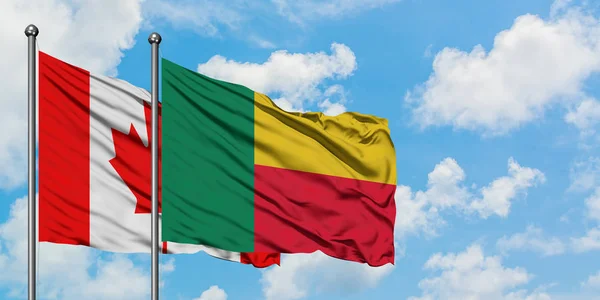 Bandera de Canadá y Benín ondeando en el viento contra el cielo azul nublado blanco juntos. Concepto diplomático, relaciones internacionales . — Foto de Stock