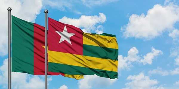 Cameroon and Togo flag waving in the wind against white cloudy blue sky together. Diplomacy concept, international relations. — Stock Photo, Image