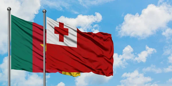 Cameroon and Tonga flag waving in the wind against white cloudy blue sky together. Diplomacy concept, international relations.