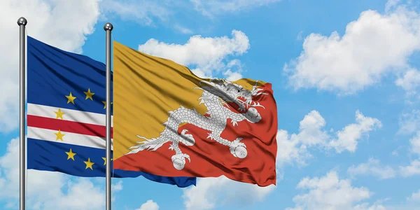 Bandera de Cabo Verde y Bután ondeando en el viento contra el cielo azul nublado blanco juntos. Concepto diplomático, relaciones internacionales . — Foto de Stock