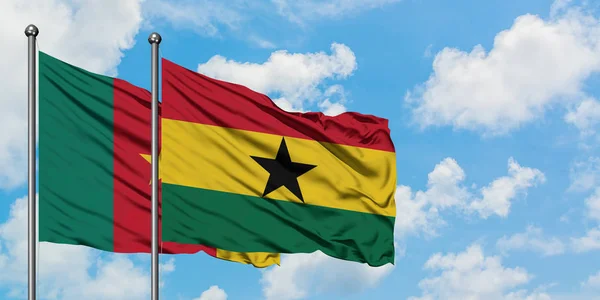 Bandera de Camerún y Ghana ondeando en el viento contra el cielo azul nublado blanco juntos. Concepto diplomático, relaciones internacionales . — Foto de Stock