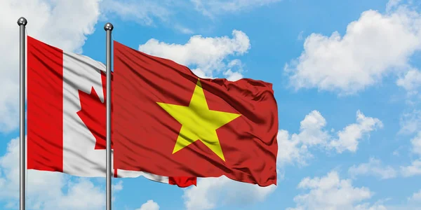 Canada e Vietnam bandiera sventolando nel vento contro bianco cielo blu nuvoloso insieme. Concetto di diplomazia, relazioni internazionali . — Foto Stock
