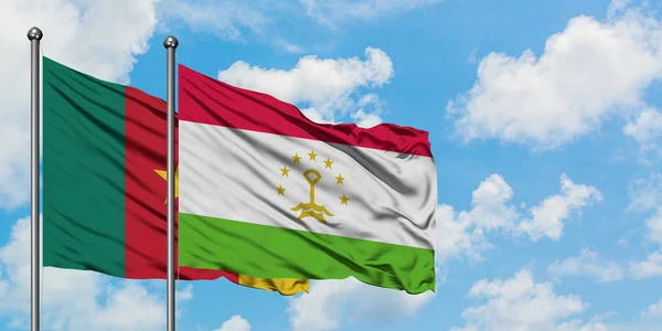 Bandera de Camerún y Tayikistán ondeando en el viento contra el cielo azul nublado blanco juntos. Concepto diplomático, relaciones internacionales . — Foto de Stock