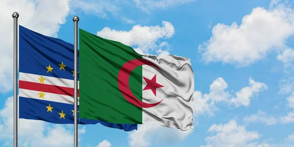 Bandera de Cabo Verde y Argelia ondeando en el viento contra el cielo azul nublado blanco juntos. Concepto diplomático, relaciones internacionales . — Foto de Stock