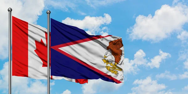 Bandera de Canadá y Samoa Americana ondeando en el viento contra el cielo azul nublado blanco juntos. Concepto diplomático, relaciones internacionales . — Foto de Stock