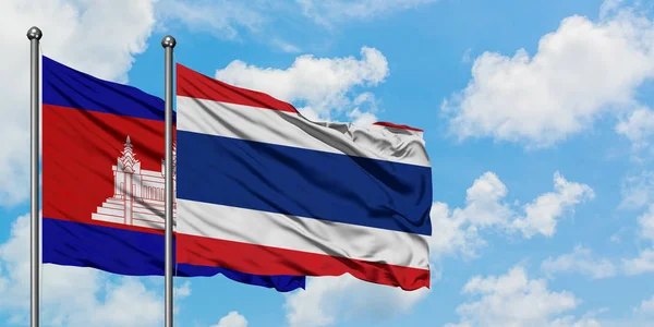 Camboja e Tailândia bandeira acenando no vento contra o céu azul nublado branco juntos. Conceito de diplomacia, relações internacionais . — Fotografia de Stock