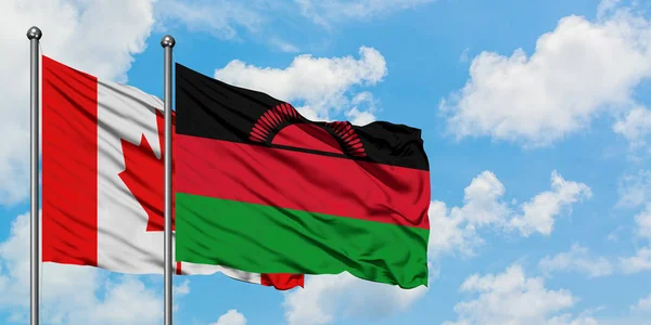 Bandera de Canadá y Malawi ondeando en el viento contra el cielo azul nublado blanco juntos. Concepto diplomático, relaciones internacionales . — Foto de Stock