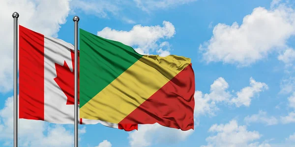 Bandera de Canadá y República del Congo ondeando en el viento contra el cielo azul nublado blanco juntos. Concepto diplomático, relaciones internacionales . — Foto de Stock