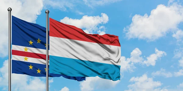 Bandera de Cabo Verde y Luxemburgo ondeando en el viento contra el cielo azul nublado blanco juntos. Concepto diplomático, relaciones internacionales . — Foto de Stock
