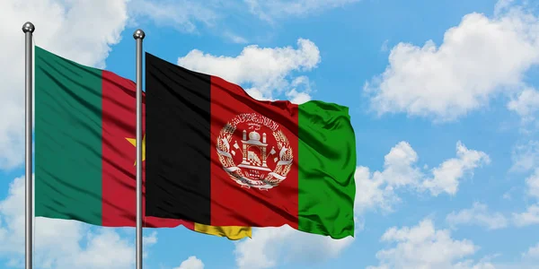 Bandera de Camerún y Afganistán ondeando en el viento contra el cielo azul nublado blanco juntos. Concepto diplomático, relaciones internacionales . — Foto de Stock
